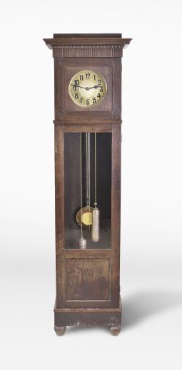 Friedrich Mauthe, Schwenningen, Germany, tall clock, 8 day, time and strike, weight driven brass movement in a dark oak case with frame and panel doors, stepped molded cornice, embossed brass dial with black steel hands.