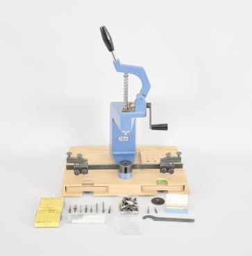 Elma Schmidbauer GmbH, Germany, KWM Universal Bushing System, clock bushing machine with lever operated quill, brass bevel gears, floating jaws, reamer / anvil / pusher set, and boxed sets of KWM brass bushings, all on wood base with dedicated spots for holding tools and supplies.