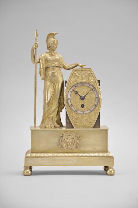 France, mantel timepiece, 8 day, time only, spring driven brass movement with thread suspension in a stepped, molded brass base upon which stands the cast gilt figure of the goddess Athena holding a spear in one hand, the other hand holding a shield within which is set a silvered chapter ring with roman numerals, blued steel Breguet style hands.