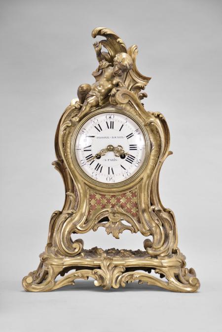 Vincenti & Cie, Paris, France, for Prosper Roussel, Paris, 8 day, time and strike, spring driven pendule de Paris movement in a gilt brass rococo style case topped by a reclining child figure, white enamel dial signed "PROSPER ROUSSEL / A PARIS", Louis XV style gilt hands.