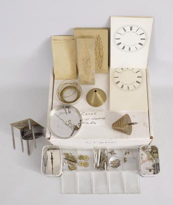 Clock Parts- Large lot of parts for Crane torsion pendulum clocks by the Year Clock Co. of New York. The lot includes one year-running movement, several pairs of fusees, mainsprings, two cases, stopworks, hands, dials and surrounds, applied cast ornaments, glasses, paper for behind the glass dials, a mold for making the pendulum spheres, movement seatboards and fusee frames, pendulum parts, a bench-made mainspring winder designed for working on the Crane, and more.