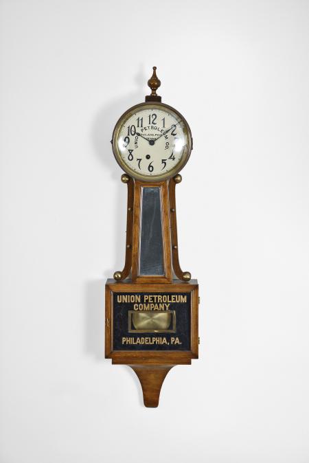 E. Ingraham & Co., Bristol, Conn., "Nyanza" banjo clock, 8 day, time only, spring driven movement in a mahogany case, painted metal dial with arabic numerals reading "Union Petroleum Co. / Philadelphia / Penna.", black spade hands.