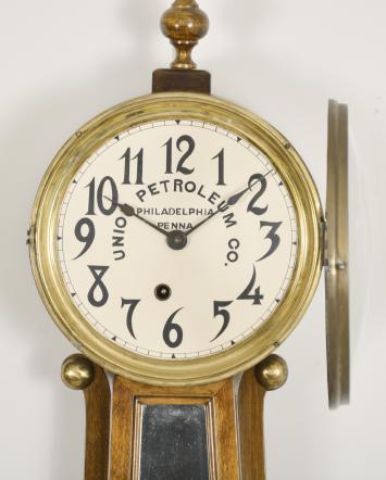 E. Ingraham & Co., Bristol, Conn., "Nyanza" banjo clock, 8 day, time only, spring driven movement in a mahogany case, painted metal dial with arabic numerals reading "Union Petroleum Co. / Philadelphia / Penna.", black spade hands.