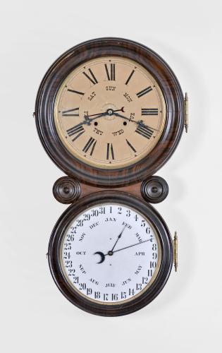 E. Ingraham & Co., Bristol, Conn., "Ionic Calendar" wall clock, 8 day, time and strike with B. B. Lewis perpetual calendar mechanism in a veneered and grain-painted case with two papered metal dials and black Maltese style hands.

