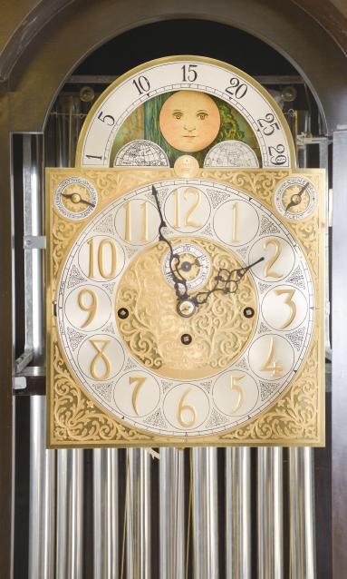 Herschede Clock Co., Cincinnati, Ohio, early 20th century tall clock with mahogany, stained dome top case with cavetto molded cornice on compressed ball feet and break arch door with beveled glasses, arabic numeral composite dial with silvered chapter ring, pierced and engraved gilt spandrels and dial center, moon phase display in the arch, and fancy blued steel hands, 8 day, three train movement chiming on tubes, and sounding Westminster, Whittington, or Canterbury quarters,  faux three jar mercury pendulum, and three polished brass weights.