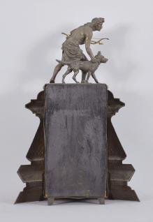 F. Kroeber Clock Co., New York, NY, "Indian Hunter V.P." mantel clock, 8 day, time and strike, spring driven brass movement in a metal front case depicting a hunter with a bow and arrow standing next to his alert canine companion, papered metal dial, and black steel Maltese style hands.