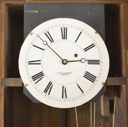 Clocks- 2 (Two): (1) Howard & Davis, Boston, Mass., "Watch Clock", softwood case with simple molded base, inset panels in base and trunk door and molded cornice, roman numeral white painted metal dial, brass 8 day timepiece movement with trapezoidal plates and turned pillars, ebonized wooden pendulum rod, damascened, brass clad, cast iron pendulum bob, and brass clad weight, c1860; (2) E. Howard & Co., Boston, Mass., hanging watch clock similar to the No. 26, rectilinear walnut case with molded cornice and applied crest, the door with molded glazed aperture for viewing the time recorder mechanism, roman numeral white painted metal dial, damascened 8 day timepiece movement, wooden pendulum rod with damascened brass clad pendulum bob, and cast iron weight, c1875.