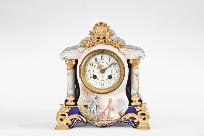 France for Bawo & Dotter, Importer, New York, USA, New York, NY, three piece mantel garniture set, 8 day, time and strike, spring driven pendule de Paris movement in a ceramic case with blue glaze and applied gilt ornaments, the front with neoclassical romantic scene signed "Petit", the dial flanked by two full ceramic columns with gilt bases and capitals, arabic numeral white enamel dial with polychrome garlands, pierced brass hands, and matching set of candelabra both with blue glaze and painted scenes.




