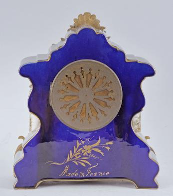 France for Bawo & Dotter, Importer, New York, USA, New York, NY, three piece mantel garniture set, 8 day, time and strike, spring driven pendule de Paris movement in a ceramic case with blue glaze and applied gilt ornaments, the front with neoclassical romantic scene signed "Petit", the dial flanked by two full ceramic columns with gilt bases and capitals, arabic numeral white enamel dial with polychrome garlands, pierced brass hands, and matching set of candelabra both with blue glaze and painted scenes.



