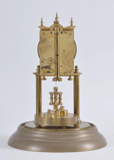 Jahresuhrenfabrik, Triberg, Germany, 400-day or "Anniversary Clock", year-running, spring driven movement with torsion pendulum and deadbeat escapement on brass base and posts, arabic numeral white enamel dial, black steel spade hands, and disc pendulum, all under a glass dome.