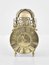 England, a miniature, 18th century lantern clock, the corners with continuous castings consisting of the turned feet, columns, and finials, the case top with strap mounted bell, and pierced, engraved fret above the 5" roman numeral brass dial with single brass hand, weight driven, brass, 30 hour movement with verge escapement and count wheel striking and passing strike at the half hour, back cock with thread suspension, resting on a purpose made oak wall bracket