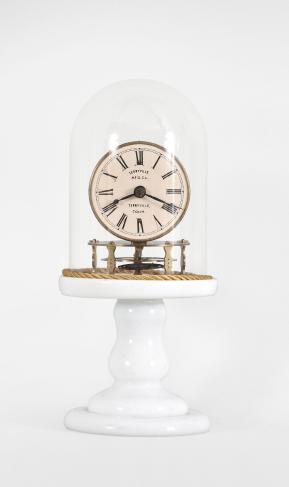 Terryville Manufacturing Company, Terryville, Conn., candle stand clock, 30 hour, time only, spring driven brass movement with four-arm balance wheel movement, 2.75 inch paper on zinc dial signed "Terryville Mfg. Co. / Terryville / Conn.", black steel hands, all on a white milk glass pedestal under small glass dome.