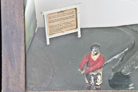 Popular Games Inc., Minneapolis, Minn., "Hoot-Mon" golf nickel arcade / skill game, made in three cabinet versions, A, B, C, golfing action figure wearing red sweater playing three holes of a par five course with painted scenery, two levers to control angle and swing and slot to accept nickel, all contained in a walnut and glass case