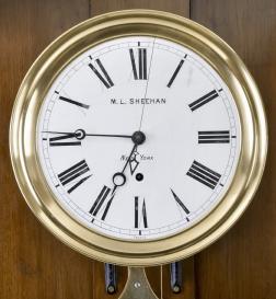 Jewelers standing regulator retailed by M.L. Sheehan, New York, New York, 8 day, time only, weight driven movement with Swiss pinwheel escapement, center seconds and gridiron lyre pendulum bearing a plaque marked M.L. Sheehan, New York , all in a carved walnut case with burl walnut highlights and white enamel dial.