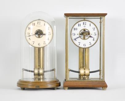 Clocks- 2 (Two) Bulle (1) Bulle Clock Co., France, Model 100 "Bulle Dome" mantel clock, time only, battery-powered electro-magnetic movement, arabic numeral painted metal dial and black steel spade hands, all under a round glass dome resting on a turned wood base, c1925; (2) Bulle-Clock, France, mantel clock, time only, battery-powered electro-magnetic movement, arabic numeral painted metal dial and black steel spade hands, all under a glazed case with mahogany base and top, c1930.