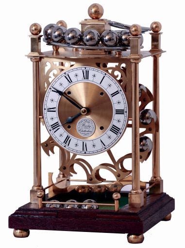 Dove Bazely Ltd., Cheltenham, England, Perpetuum clock, polished brass portico style case with mahogany base, Roman numeral silvered dial, 8 days, timepiece movement powered by a spring, and 24 steel balls, which drop from the rail on the case top onto the "ferris wheel" attached to the winding arbor behind the movement, with paperwork, c1986