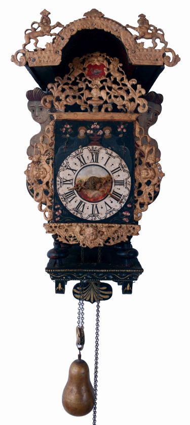Frisian stoelklok, polychrome painted shelf with mermaids and painted floral decoration, lead ornaments with gilding and with painted swan, Roman numeral painted, arcaded dial with a disturbing pair of reclining figures, urn with flowers, and central vignette with landscape and a building, pierced brass hands, typical baluster turned brass four pillar, time and strike movement with alarm, bell hammer arbor of brass and with matching baluster turnings, large brass pear shaped weight, late 18th- early 19th century