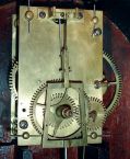 Boston 8 days, weight driven brass movement patent or banjo timepiece, c1825. Possible Simon Willard banjo as it is early with a head that is a uniform 1/2 inch thickness and has a very thin backboard. The movement has T-bridge suspension, through bolts to secure the movement. There are holes in the keystone for a crossbar. The throat frame is rabbeted on the back side and recessed into the sides of the case and anchored to the case with four screws. The door is latched to the case with an L-turn.