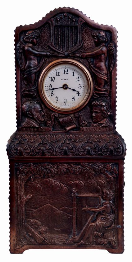 Ansonia Clock Co., New York, NY, "Harmony" novelty clock with two tune music box in base, bronze finished cast iron case, the base with a harpist in a landscape, the upper section with Arabic numeral dial marked "Harmony", with flanking putti and lyre, also with busts of Wagner and Beethoven, 30 hours, timepiece movement, c1900