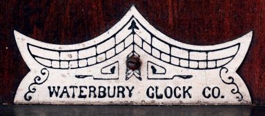 Waterbury Clock Co., Waterbury, Conn., "Eton" wall hanging clock in a walnut case with a spring driven, 8 days, time and strike movement, c1906.