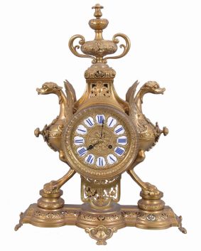 France, figural brass mantel clock, 8 day, time and strike on a pierced base with two short pillars supporting winged griffon figures in profile flanking a central cylinder holding an ornate brass dial with blued steel hands and white enameled cartouche numerals in blue, surmounted by a decorative urn. The pendule de Paris movement with partially exposed pendulum is stamped "CHLES MT".