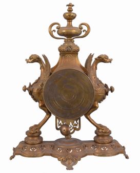 France, figural brass mantel clock, 8 day, time and strike on a pierced base with two short pillars supporting winged griffon figures in profile flanking a central cylinder holding an ornate brass dial with blued steel hands and white enameled cartouche numerals in blue, surmounted by a decorative urn. The pendule de Paris movement with partially exposed pendulum is stamped "CHLES MT".