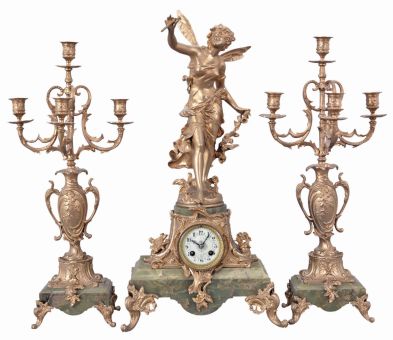 France, three-piece figural mantel clock with garniture, green onyx base on cast rococo feet supporting clock with porcelain dial set within an ornate tapered column, surmounted by a cast spelter female figure with delicate wings. The movement is an 8 day spring driven time and strike pendule de Paris signed by Marti & Cie. Matching onyx and cast metal candelabra hold four candles each.