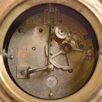 France, three-piece figural mantel clock with garniture, green onyx base on cast rococo feet supporting clock with porcelain dial set within an ornate tapered column, surmounted by a cast spelter female figure with delicate wings. The movement is an 8 day spring driven time and strike pendule de Paris signed by Marti & Cie. Matching onyx and cast metal candelabra hold four candles each.