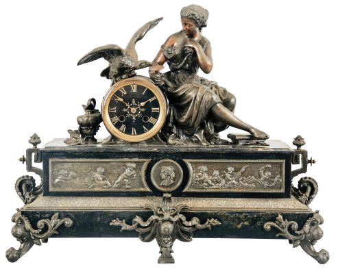 France, Figural Mantel Clock with Electric Movement, patinated Belgian slate case with brass and spelter figure and decoration, a seated young lady holding grapes and feeding a large raptor perched on top of the black and gold dial with roman numerals and gilt spade hands, the lower section of the case with classical puti facade centering on a goddess profile, all on feet of claw and ball feet and central bracket, the movement now with antiquated electric movement.