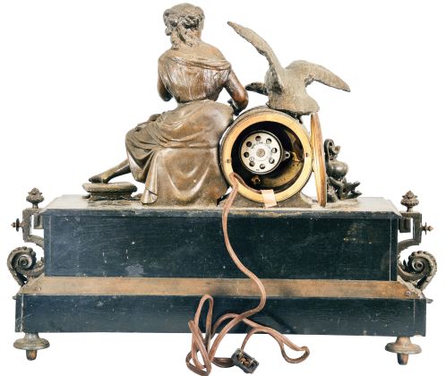 France, Figural Mantel Clock with Electric Movement, patinated Belgian slate case with brass and spelter figure and decoration, a seated young lady holding grapes and feeding a large raptor perched on top of the black and gold dial with roman numerals and gilt spade hands, the lower section of the case with classical puti facade centering on a goddess profile, all on feet of claw and ball feet and central bracket, the movement now with antiquated electric movement.