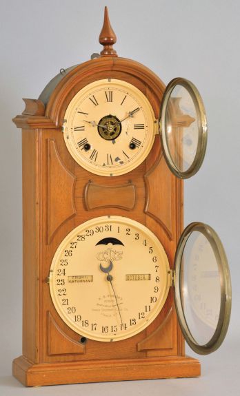 Ithaca Calendar Clock Co., Ithaca, New York, "No. 8 Shelf Library" double dial calendar clock with a spring driven, 8 day time, strike and alarm movement in a walnut case.