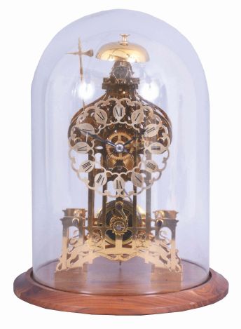 England, signed Smith, Clerkenwell, c1890 chain fusee pub movement, now in a modern skeletonized frame representing Brighton Pavilion, the frame appearing to have been cut on an EDM wire machine, and then polished by hand. The silvered dial is nicely fretted and the Roman Numerals are sharply engraved and black filled. The frame surmounted by a bell that is struck once on the passing of each hour. Covered by a round glass dome and mounted on a turned walnut base.