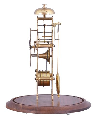 England, signed Smith, Clerkenwell, c1890 chain fusee pub movement, now in a modern skeletonized frame representing Brighton Pavilion, the frame appearing to have been cut on an EDM wire machine, and then polished by hand. The silvered dial is nicely fretted and the Roman Numerals are sharply engraved and black filled. The frame surmounted by a bell that is struck once on the passing of each hour. Covered by a round glass dome and mounted on a turned walnut base.