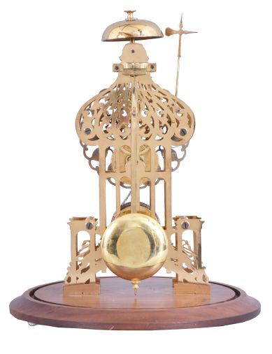 England, signed Smith, Clerkenwell, c1890 chain fusee pub movement, now in a modern skeletonized frame representing Brighton Pavilion, the frame appearing to have been cut on an EDM wire machine, and then polished by hand. The silvered dial is nicely fretted and the Roman Numerals are sharply engraved and black filled. The frame surmounted by a bell that is struck once on the passing of each hour. Covered by a round glass dome and mounted on a turned walnut base.