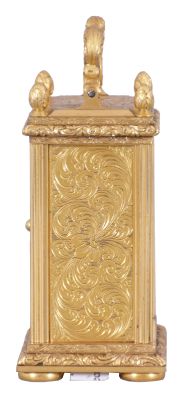 England, a very decorative miniature carriage timepiece, the gilt case with expertly engraved foliate ornament, the corners with reeded columns, surmounted by chased and engraved finials, the top with acanthus decorated handle, Roman numeral silvered dial with engraved center and gilt, engraved mask, blued steel Breguet style hands, 8 day timepiece movement with lever escapement, and spring barrel fixed to the front plate