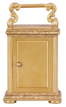 England, a very decorative miniature carriage timepiece, the gilt case with expertly engraved foliate ornament, the corners with reeded columns, surmounted by chased and engraved finials, the top with acanthus decorated handle, Roman numeral silvered dial with engraved center and gilt, engraved mask, blued steel Breguet style hands, 8 day timepiece movement with lever escapement, and spring barrel fixed to the front plate