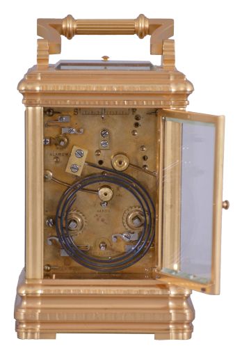 Margaine, Paris, for J.E. Caldwell, Philadelphia, a large and decorative striking carriage clock, the gilt Gorge variant case set with beveled glasses, engine turned silvered dial mask surrounding the time and alarm displays, each with gilt decorated black ground, and with convex, white, egg shaped reserves for the red Roman and Arabic numerals, gold spade and poker hands, 8 day time, strike and alarm movement with lever platform, repeating the last hour on demand, the back plate with Margaine