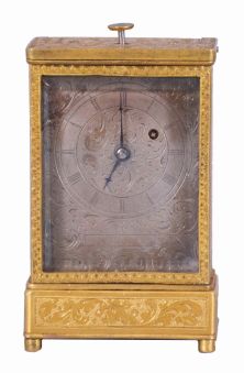 Austria, quarter repeating miniature carriage clock, the rectilinear, gilt brass case on turned feet, front and sides with foliate engraving, carrying handle folding flush with the case top, Roman numeral silvered dial, with engraving matching the case, blued steel hands, round, 30 hour verge fusee movement with blued steel gongs, repeating the last hour and quarter on demand, together with its original leather covered, wooden travel case