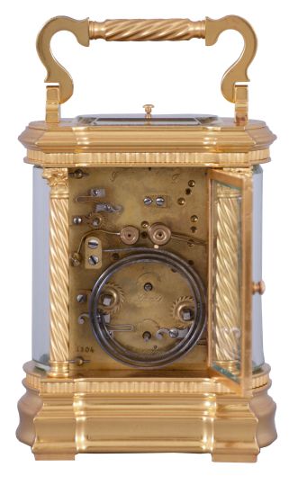 France, a large and extremely decorative carriage clock with grand sonnerie striking, unusual gilt Anglaise variant case with twist columns having Corinthian capitals and turned bases, the molded base and cornice with bowed sides and conforming beveled glasses, top with twist ornamented handle matching the columns, red guilloche enamel dial with convex chapter and gilt Arabic numerals, ornate pierced and chased, gilt dial mask with lily of the valley ornament, gold hands, 8 day time, strike, and alarm movement with lever platform and cut bimetallic balance, sounding grand or petit quarters in passing, and repeating the last hour and quarter on demand, serial #1304, with original leather bound box and key