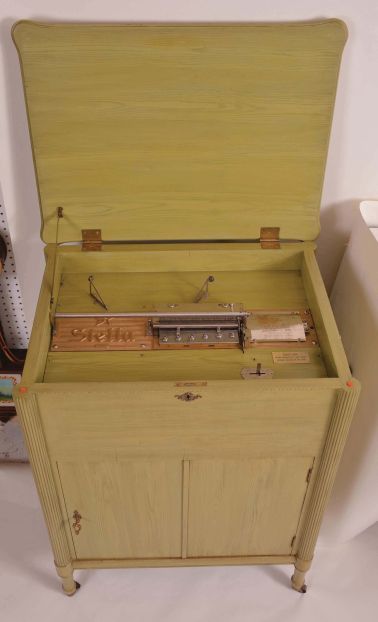 Music Box- Switzerland, "STELLA", 17 1/4 inch disc playing console music box,3 feet high, the cabinet painted appliance green in 1950, and with 40 discs, cabinet door opens and provides storage area for many discs.