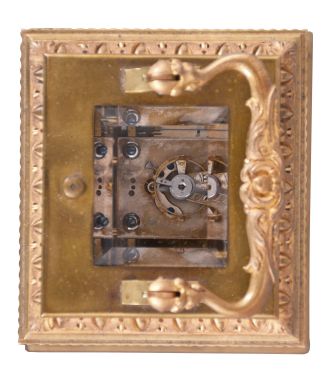 France, for Tiffany & Co., a Pillars style, petit sonnerie striking carriage clock with repeat, the glazed, gilt case with bright and matte surfaces, the base and cornice with cavetto and egg and dart moldings, the corners with acanthus decorated columns, and carrying handle also with foliate ornament, Arabic numeral white enamel dial with fretted, matte gilt foliate mask against a bright gilt background, blued steel distaff hands, 8 day time, strike, and alarm movement with lever platform, sounding petit sonnerie quarters in passing, with grand sonnerie repeating on demand, the base with strike/ silent lever
