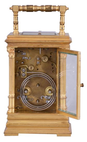 France, for the English market, a fine Pillars style repeating carriage clock with porcelain panels by Lucien Simonnet, the gilt case with stepped, molded base, the corners with fluted columns and Corinthian capitals supporting the molded cornice, the folding handle with turned ornament, case sides set with signed, polychrome enamel scenes depicting colorfully dressed young women in a garden, the Roman numeral dial surrounded by a landscape scene with castle ruins and floral garlands, blued steel distaff hands, 8 day time, strike, and alarm movement with lever platform, and repeating the last hour on demand, serial #2277