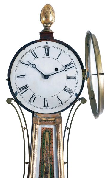 Patent Timepiece or "Banjo" Clock, Concord, Massachusetts, the mahogany veneered, gilded rope molded case with acorn finial over the zinc roman numeral dial, original reverse-painted glasses, the lower depicting "Aurora" on her festooned chariot driven by two winged horses set before a gleaming sunrise and framed within a geometric border, the waist glass flanked by brass side ornaments in gold, green and red frames gilt scroll work within a gilt border, below is a gilded pedestal with fluted acorn drop and eight balls, eight day brass movement with alternate train layout, cut-outs on front and back plates, and recoil escapement and regulated by a brass-faced lead backed pendulum bob and iron rod.