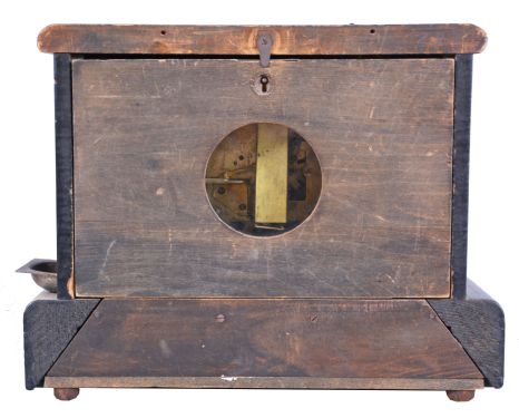 Loheide MFG. Co., St. Louis, Mo., "Automatic Sales Machine" clock and trade stimulator (often called a gambling clock). 8 day, time and token dispenser, spring driven in a black enameled wood case. The clock has a coin slot at the top. When a nickel was deposited, it triggered the strike train of the clock which drives a token dispensing system. A modified countwheel will dispense one, two, and on rare occasion, three tokens in the tray mounted to the side of the clock. Tokens were then exchanged for small items at the retail location.