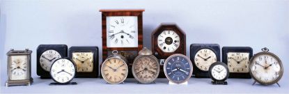 Clocks- 13 (Thirteen) American: two 19th century cottage models, plus later alarm clocks and desk timepieces. Alarms include 6 from WWII, "War Alarms" as printed on the dials, four of these are in square, hard molded paper mache cases with original black finish. 4 mixed nickel plated alarms (one in a carriage style case) and a mid century Westclox Big Ben.