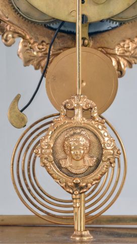 Ansonia Clock Co., New York, "Excelsior" crystal regulator, 8 day, time and strike, spring driven movement with visible Brocot escapement in a gilt finished brass case on claw feet, cream porcelain dial with Roman numerals and red interstitial decorations, cast pendulum with female face, strikes on cathedral gong.
