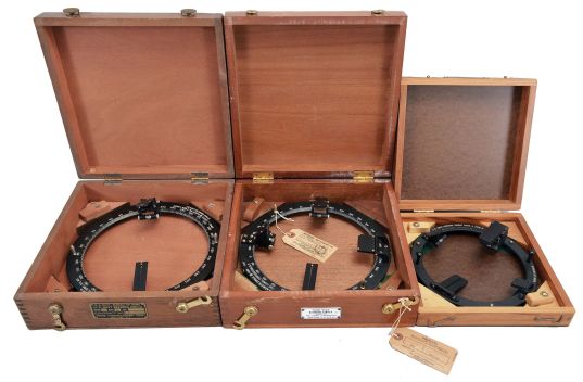 Azimuth Circles- 3 (Three) U.S. Navy Azimuth and Bearing Circles: (1) Q-O-S Corp., New York, "U.S. Navy 6 Inch Azimuth Circle, Mark 4 Mod. 0", 8.25 inch outside diameter ring in fitted wood case, dated 1964. (2) The Lionel Corporation, New York, "Type 712A Azimuth Circle", 10.25 inch outside diameter in finger-jointed mahogany box, dated 1943. (3) Pathe Manufacturing Corp., New York, "U.S. Bearing Circle, Mark I Model 2", 10 inch outside diameter, in a finger-jointed mahogany case, dated 1943.