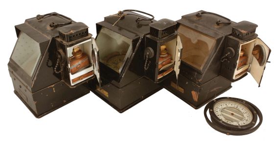 Instruments- 3 (Three) U.S. Navy Boat Binnacles: Beck-Lee Corporation, Chicago, and the Lionel Corporation, New York, "U.S. Navy Standard Boat Binnacle", black painted sheet copper, bail handles, beveled glasses, illumination via oil lamp mounted on side of case, each with a 4 inch compass.
