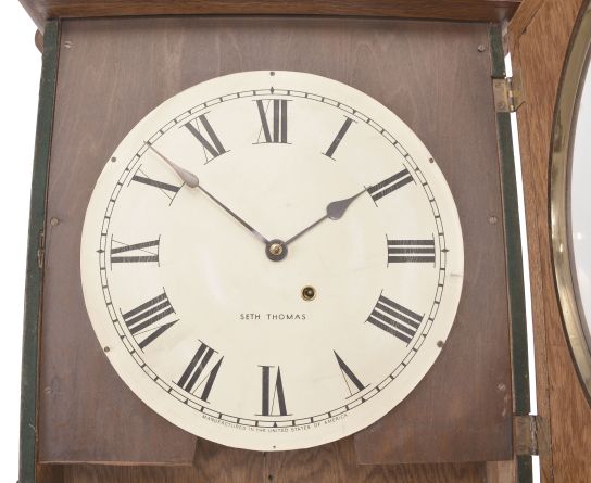 Seth Thomas Clock Co., Thomaston, Conn., "Office No. 5" wall clock, 8 day, time only, spring driven movement in an oak case with 12 inch papered metal dial, blued steel spade hands.