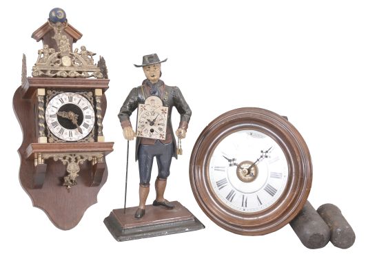Clocks- 3 (Three): (1) Dutch reproduction wall clock, 8 day, time and strike, weight driven movement in a mahogany case with cast brass ornaments, silvered chapter ring, and topped by a figure supporting a sphere of the heavens, c1970; (2) Black Forest, Germany, two-weight wall or "postal" clock, 30 hour, time and alarm, weight driven wood-plate movement with a turned wood bezel and back-painted glass dial, c1880; (3) Peddler figure novelty clock, 30 hour, time only, spring driven movement in a painted cast metal figural case depicting a German clock peddler carrying two wag-on-the-wall clocks, c1990.